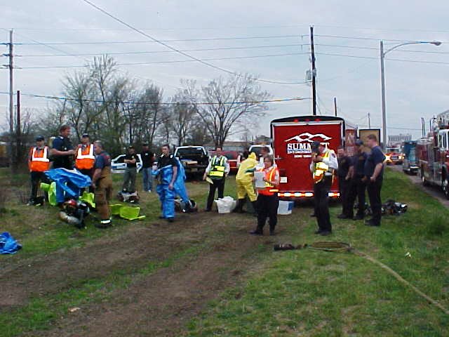 Large group of fire fighters getting their protective gear on.